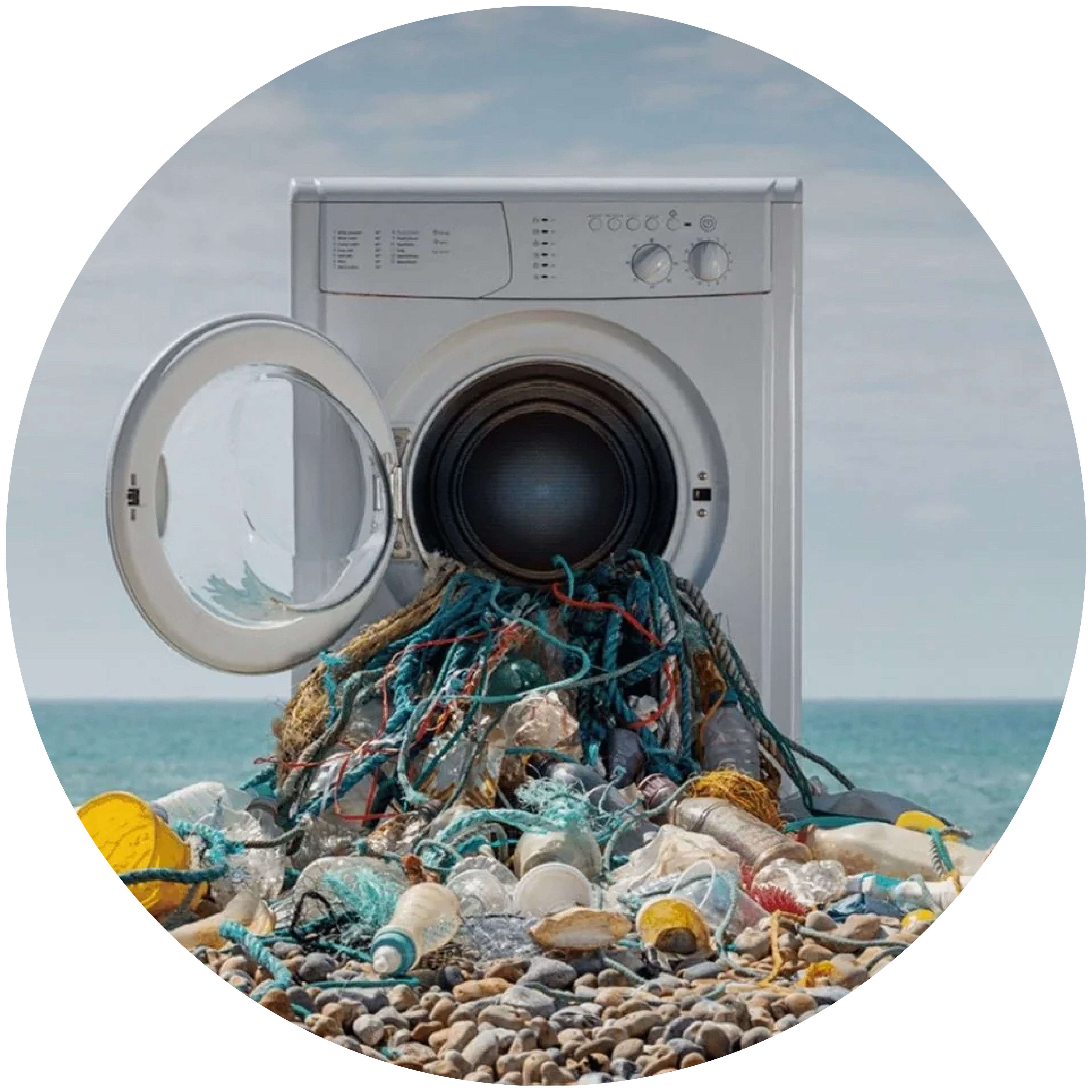 A washing machine with plastic items and bottles pouring out of the front. Photo credit PlanetCare